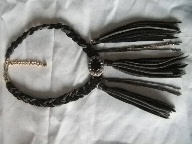 Collier artisanal en cuir tresse noir et gris avec un motif central. Jigée Jigée